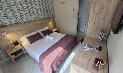 una camera con un grande letto con testiera in legno di Hotel Adigrat a Riccione