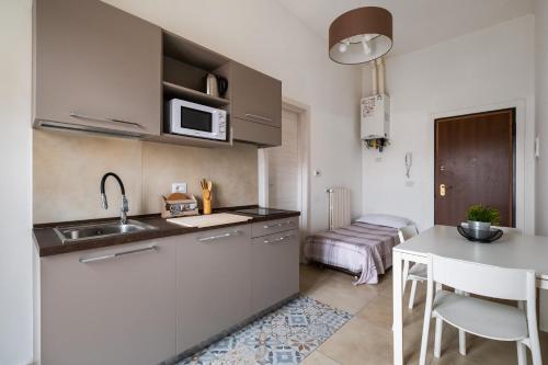 eine kleine Küche mit einem Waschbecken und einem Tisch in der Unterkunft Palazzina Carracci in Bologna