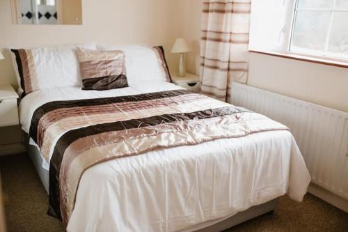 a bedroom with a white bed with a window at Portora House in Silverhill