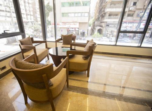 um restaurante com cadeiras, uma mesa e janelas em Stay Inn Cairo Hotel no Cairo