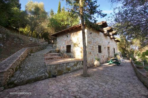 a stone building with a tree in front of it at Kefalonian Luxury Villas in Kástron