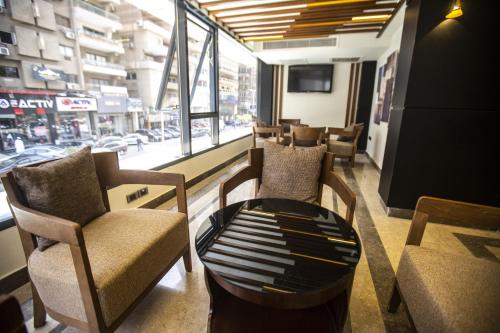 Stay Inn Cairo Hotel في القاهرة: غرفة بها كراسي وطاولة ونافذة