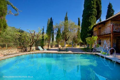 a large swimming pool in a yard with trees at Kefalonian Luxury Villas in Kástron