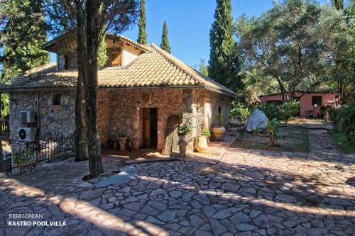 a stone house with a tree in front of it at Kefalonian Luxury Villas in Kástron