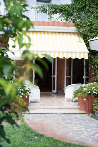 a building with a yellow awning and a porch at Villa Arizona in Milano Marittima