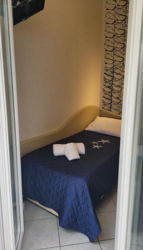 a bedroom with a blue bed with two towels on it at Hotel Adigrat in Riccione