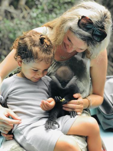 a woman holding a young child holding a baby monkey at Villa 252 Kosgoda in Kosgoda