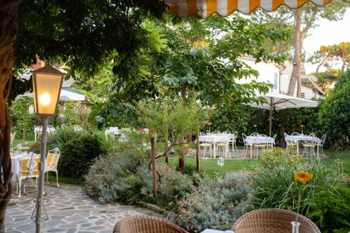 a garden with tables and chairs and a street light at Villa Arizona in Milano Marittima