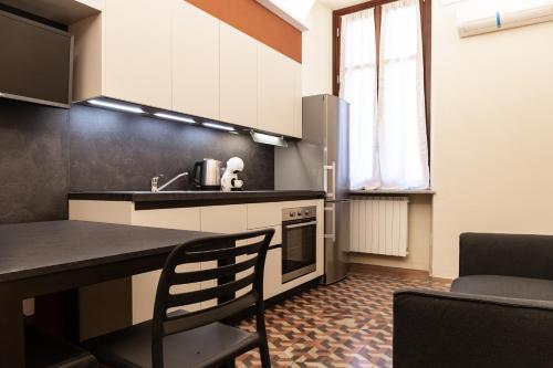 uma cozinha com um balcão, um lavatório e uma mesa em ROMA COMFORT em Casale Monferrato