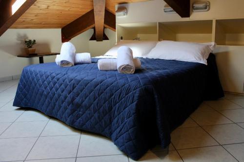 a bedroom with a large bed with blue comforter at Hotel Adigrat in Riccione