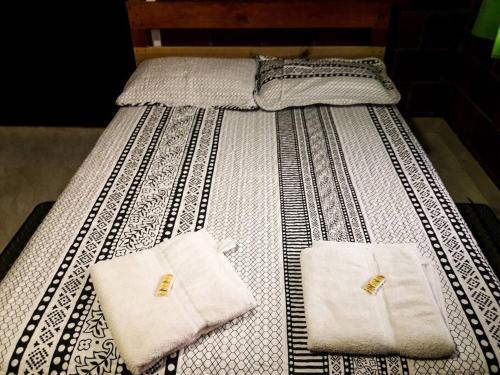 Hostal Casa del Viento Kitesurf & Adventure في كاليما: سرير وفوط بيضاء فوقه
