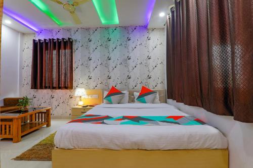 a bedroom with a large bed with a purple lighting at FabExpress Moti Mahal in Varanasi