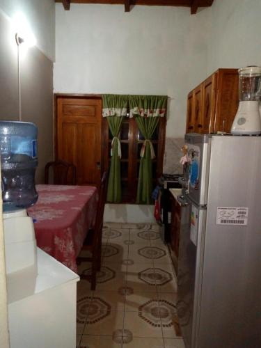 a kitchen with a refrigerator and a table with a red table cloth at Alvar Nuñez in Puerto Iguazú