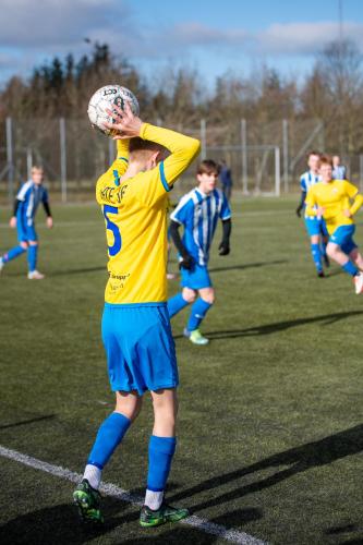 a man holding a soccer ball on a field at Idrætscenter Jammerbugt in Fjerritslev