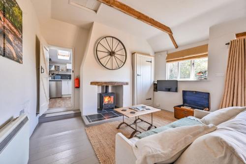 a living room with a couch and a fireplace at The Bothy - a cosy little rustic barn in Parracombe