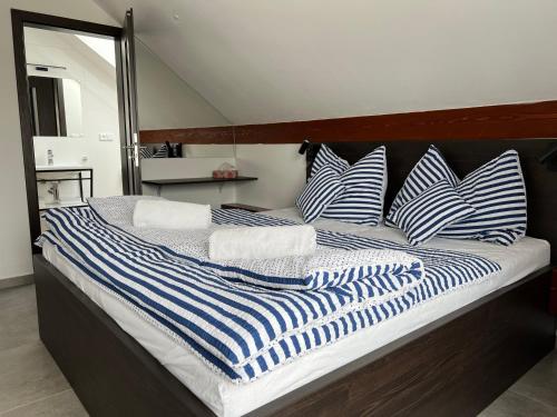 a large bed with blue and white striped pillows at Apartmán D5 Nová Pec in Nová Pec