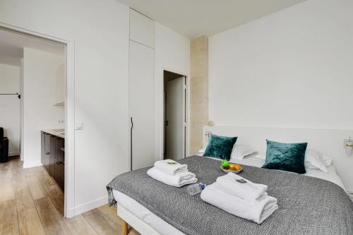 une chambre avec un grand lit avec des serviettes dessus dans l'établissement Chic Apartment -2BR-6P- Oberkampf-République, à Paris