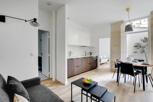 un salon et une cuisine avec un canapé et une table dans l'établissement Chic Apartment -2BR-6P- Oberkampf-République, à Paris