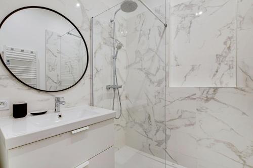 une salle de bain blanche avec un lavabo et un miroir dans l'établissement Chic Apartment -2BR-6P- Oberkampf-République, à Paris