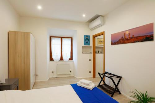 a bedroom with a bed with a blue blanket at SweetLittleHouse47 - Dentro le mura, parcheggio gratuito in Siena
