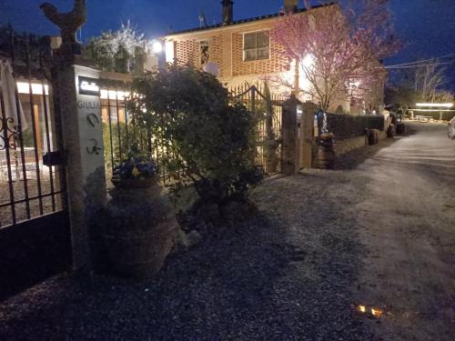 a fence in front of a house at night at La Limonaia Country House in Monteriggioni