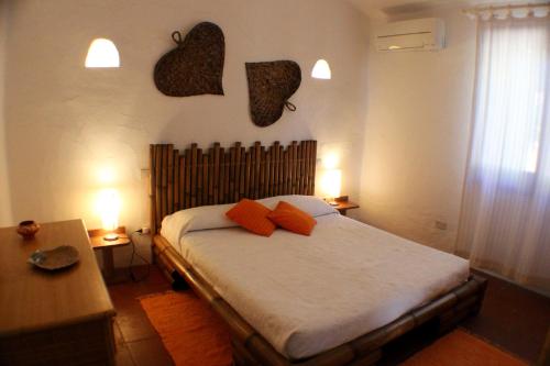 1 dormitorio con 1 cama con almohadas de color naranja en Villa Orchidea, en San Stèfano