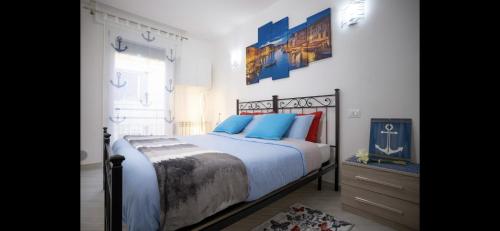 a bedroom with a large bed with blue pillows at New Apartment Venice - 8 min from San Marco Square in Venice