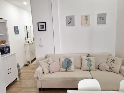Sea Suite 26 في سيلا: غرفة معيشة مع أريكة عليها وسائد