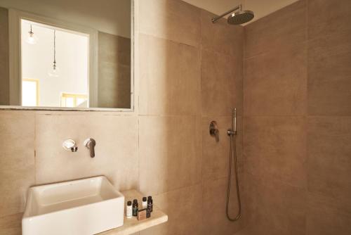 W łazience znajduje się prysznic, umywalka i lustro. w obiekcie TOWN BOX w mieście Mykonos