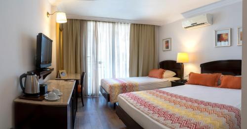 pokój hotelowy z 2 łóżkami i telewizorem w obiekcie Akdora Resort Hotel & Spa w Side