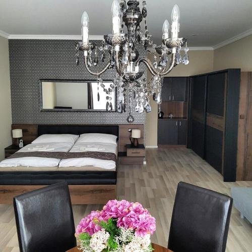a bedroom with a bed and a chandelier at Ubytování Cukrovar in Lovosice