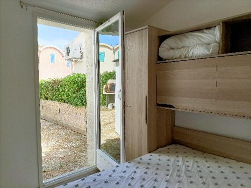 um quarto com uma cama e uma porta de vidro deslizante em Maison avec piscine collective sur Gruissan 6MIN39 em Gruissan