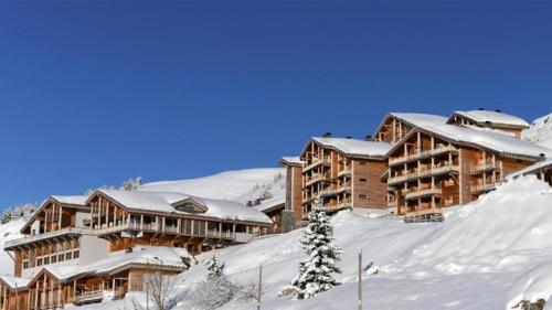 un rifugio nella neve con edifici coperti da neve di Résidence Les Portes du Grand Massif - Flaine a Flaine