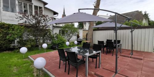 a patio with a table and chairs and an umbrella at Villa Helga- Ferienwohnung Abendmond mit Terrasse und 2 Schlafzimmern in Zinnowitz