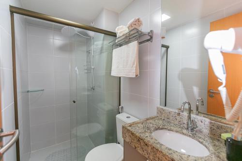 a bathroom with a shower and a toilet and a sink at Manaíra Apart Flat in João Pessoa