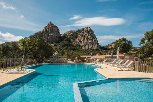 une piscine avec une montagne en arrière-plan dans l'établissement Sapa Di Cala, à Bonifacio
