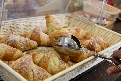 a person holding a spoon in a basket of pastries at Hotel Adigrat in Riccione