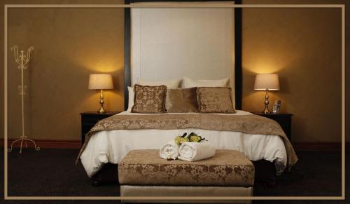 a hotel room with a bed with two towels and two lamps at Water on Waldrift Guesthouse in Vereeniging
