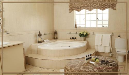 a bathroom with a tub and a toilet and a sink at Water on Waldrift Guesthouse in Vereeniging