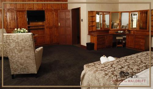 a hotel room with a bed and a desk at Water on Waldrift Guesthouse in Vereeniging
