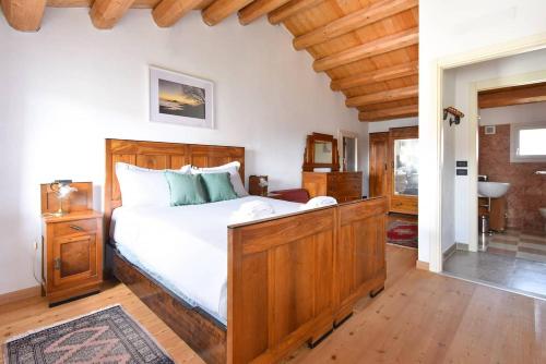 um quarto com uma cama grande e uma estrutura em madeira em Calaone Wondeful Duplex Apartment con parcheggio x4 em Baone