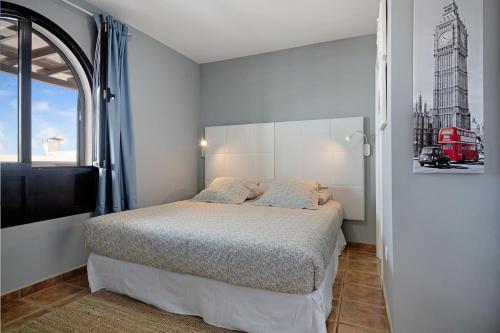 sypialnia z łóżkiem i dużym oknem w obiekcie Apartamento La Estrella ii w mieście Playa Blanca