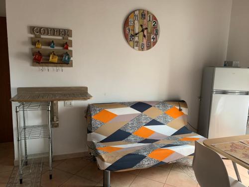 a kitchen with a couch and a clock on the wall at Bed and Breakfast Dolly in SantʼAntìoco