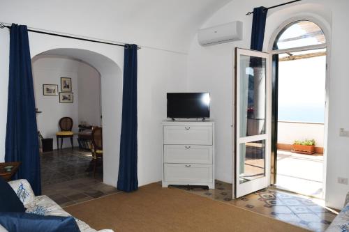 uma sala de estar com um espelho e uma televisão em La Terrazza Apartment em Capri