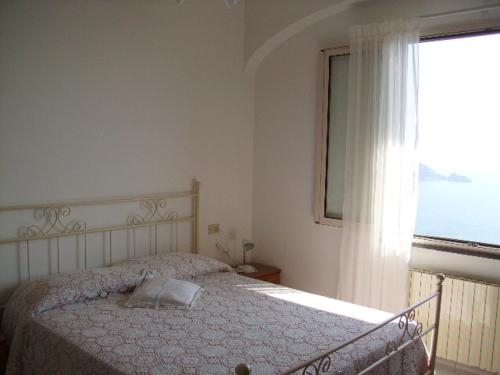 a bedroom with a bed in front of a window at casa Lux in Praiano