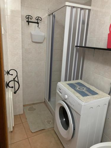 a washing machine in a bathroom with a shower at Bed and Breakfast Dolly in SantʼAntìoco