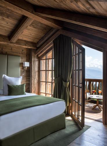 une chambre avec un lit et une porte coulissante en verre dans l'établissement Le Refuge de la Traye, à Méribel