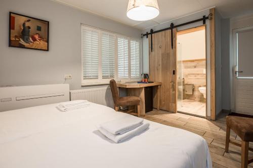 a bedroom with a bed and a table and a desk at Hotel Giethoorn in Giethoorn