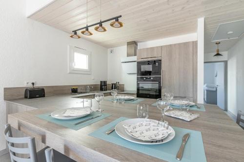 une cuisine et une salle à manger avec une table et des verres à vin dans l'établissement Appartement pour 4 - 450m Plage des Sables d'Or, à La Guérinière