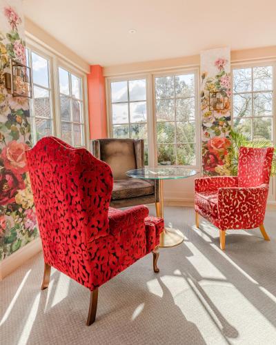 a room with two chairs and a table and windows at Park Farm Hotel in Norwich